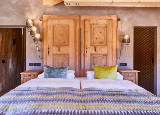 Schlafzimmer mit Doppelbett und Holzmöbeln - Suite Dolomites Mountain Spa