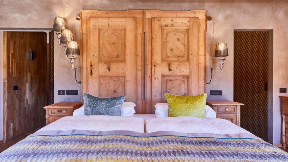 Schlafzimmer mit Doppelbett und Holzmöbeln - Suite Dolomites Mountain Spa