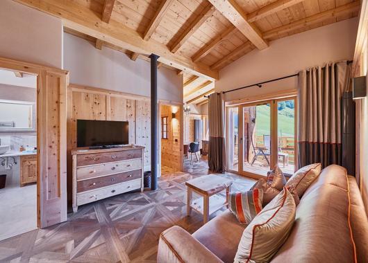 Soggiorno in stile ladine con divano e TV - Suite Dolomites Mountain Spa