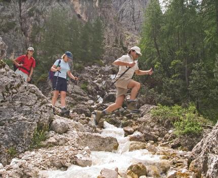 Wandergruppe überquert einen Bach