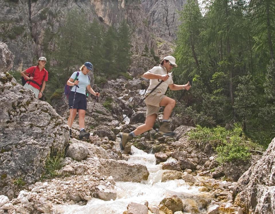 Wandergruppe überquert einen Bach