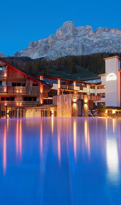 Sky Pool mit Aussicht auf die Dolomiten am Abend