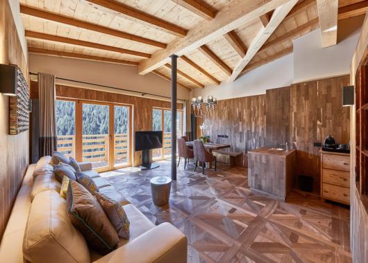 Stua Ladina con divano in pelle e mobili in legno - Suite Dolomites Mountain Spa